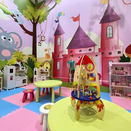 เอเวอร์กรีน เลาเรล โฮเต็ล ไทชุง Hotel ไถจง ภายนอก รูปภาพ The photo shows a colorful children's playroom designed with a whimsical theme. The walls are painted in bright colors and feature a cartoon-style mural of a pink castle with purple towers and a smiling cartoon elephant. The room is filled with playf