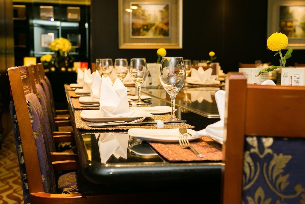 เอเวอร์กรีน เลาเรล โฮเต็ล ไทชุง Hotel ไถจง ภายนอก รูปภาพ The photo depicts a dining table set for a formal meal. The table is long, covered with a dark tablecloth, and has neatly arranged plates, forks, and glasses at each setting. White napkins are folded elegantly, and there are small yellow flowers as c