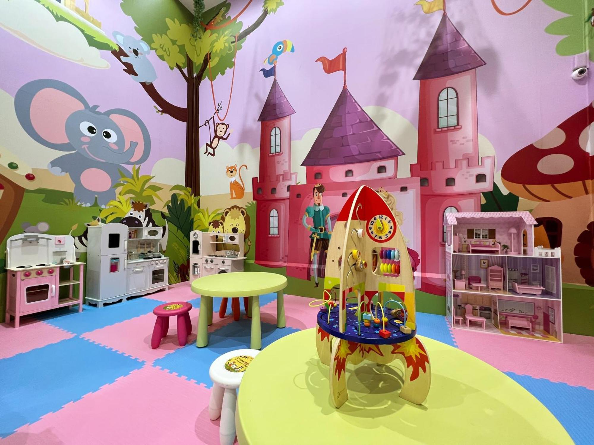 เอเวอร์กรีน เลาเรล โฮเต็ล ไทชุง Hotel ไถจง ภายนอก รูปภาพ The photo shows a colorful children's playroom designed with a whimsical theme. The walls are painted in bright colors and feature a cartoon-style mural of a pink castle with purple towers and a smiling cartoon elephant. The room is filled with playf