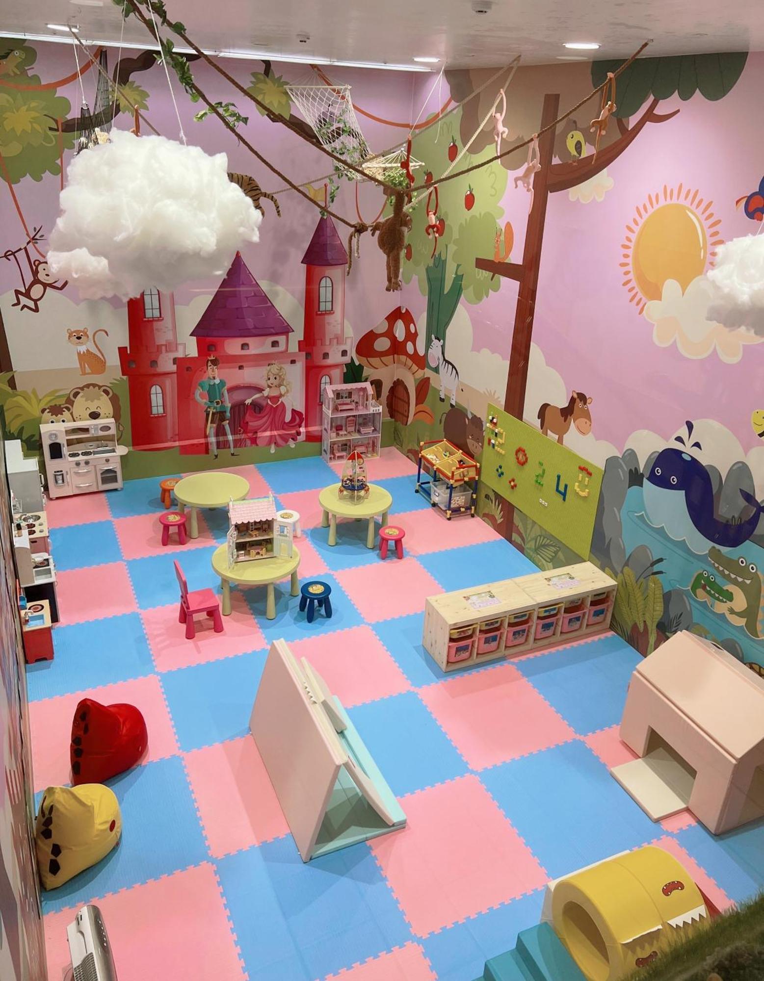 เอเวอร์กรีน เลาเรล โฮเต็ล ไทชุง Hotel ไถจง ภายนอก รูปภาพ The photo shows a colorful playroom designed for children. It features a vibrant mural with a fairytale castle, trees, and playful animals on the walls. The floor is covered with interlocking foam tiles in pink and blue, providing a soft play surface