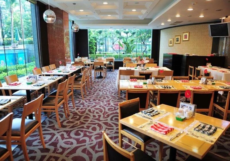 เอเวอร์กรีน เลาเรล โฮเต็ล ไทชุง Hotel ไถจง ภายนอก รูปภาพ The photo shows an interior of a restaurant with a spacious layout. There are several wooden tables, each set with napkins and utensils. The floor has a decorative carpet, and large windows provide a view of greenery outside. The lighting is bright, 