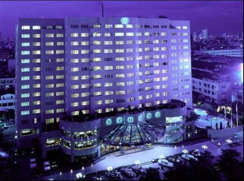 เอเวอร์กรีน เลาเรล โฮเต็ล ไทชุง Hotel ไถจง ภายนอก รูปภาพ The photo shows a large hotel building illuminated in a purple hue during the evening or nighttime. The facade features numerous windows, many of which are lit, suggesting occupancy. The entrance area appears modern and curved, with a design that inc