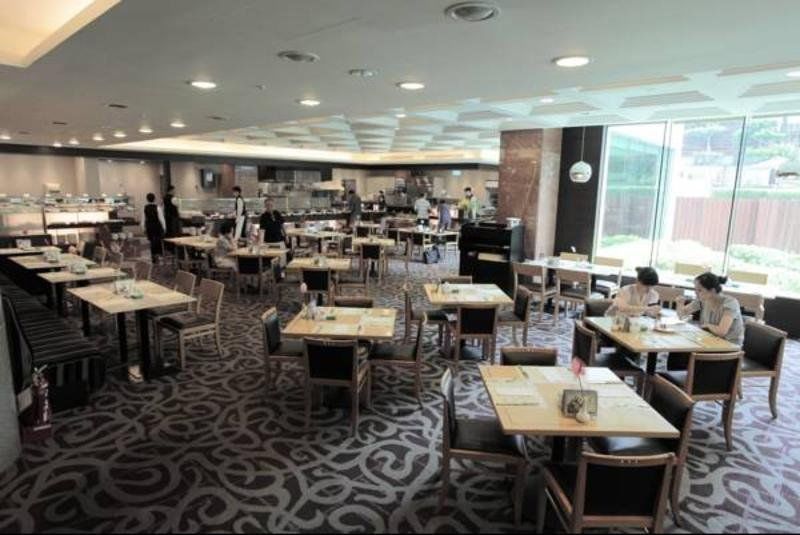 เอเวอร์กรีน เลาเรล โฮเต็ล ไทชุง Hotel ไถจง ภายนอก รูปภาพ The photo shows a spacious restaurant or dining area with a modern interior design. There are several tables arranged throughout the room, some of which are set for dining while others appear to be empty. The decor includes a patterned carpet and lar