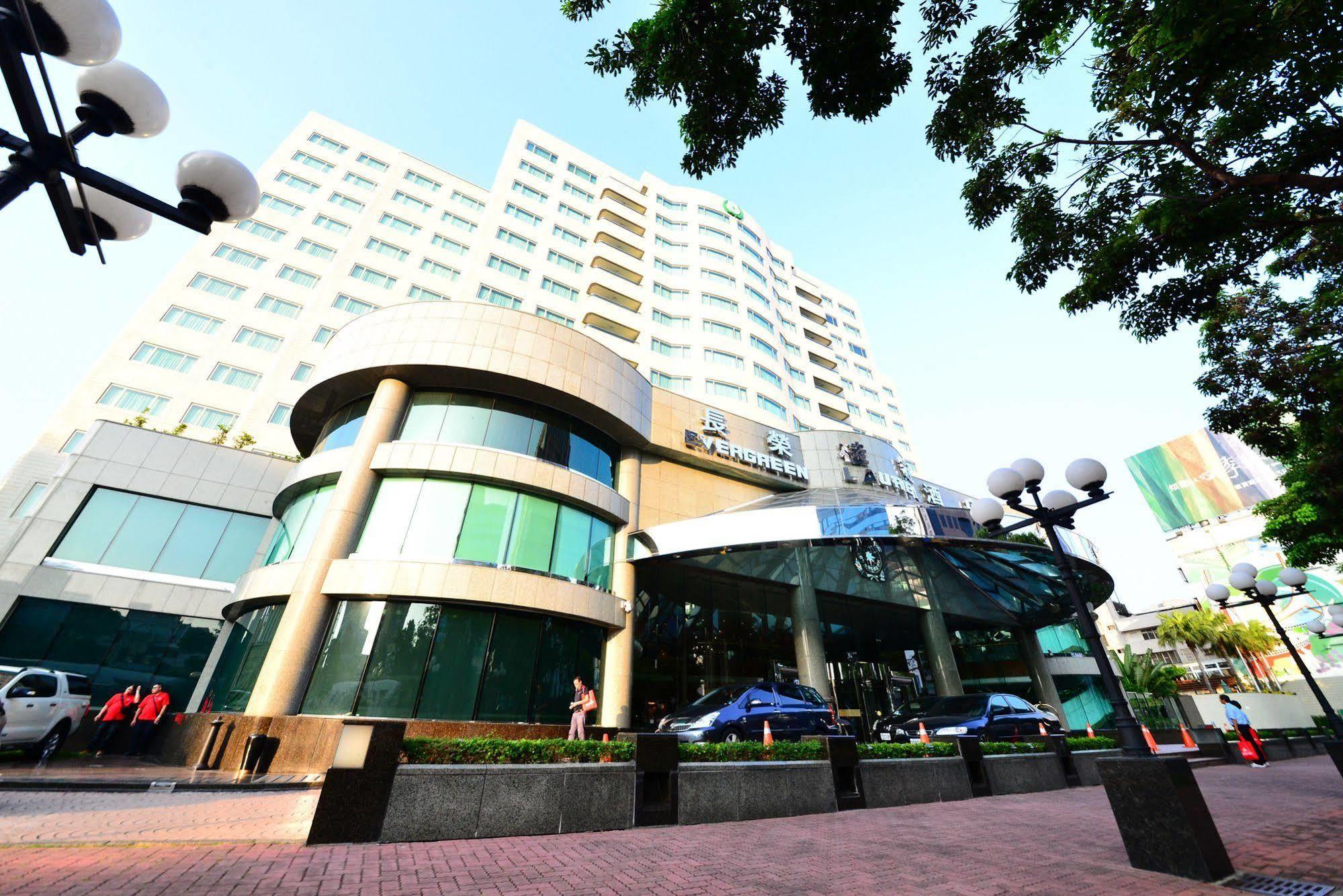 เอเวอร์กรีน เลาเรล โฮเต็ล ไทชุง Hotel ไถจง ภายนอก รูปภาพ The photo shows a modern multi-story building, which appears to be a hotel or commercial establishment. The structure has a rounded glass entrance with a distinctive architectural design, featuring large windows. The building is surrounded by greener