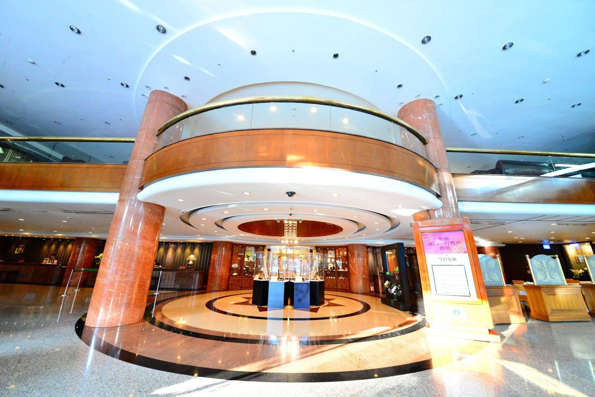 เอเวอร์กรีน เลาเรล โฮเต็ล ไทชุง Hotel ไถจง ภายนอก รูปภาพ The photo shows the interior of a spacious lobby area. It features a modern architectural design with polished surfaces and a circular ceiling structure. The walls are accented with wooden panels, and there is a central chandelier hanging from the ce