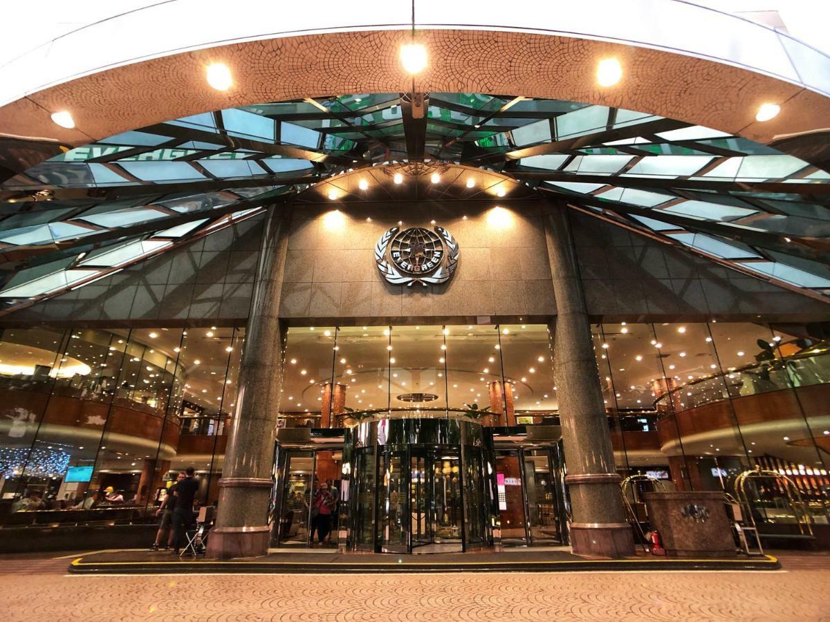 เอเวอร์กรีน เลาเรล โฮเต็ล ไทชุง Hotel ไถจง ภายนอก รูปภาพ The image shows the entrance of a modern building, likely a hotel or a luxury establishment. The entrance features a large revolving door surrounded by glass panels. Above the entrance, there is a prominent logo or emblem. The overall architectural d