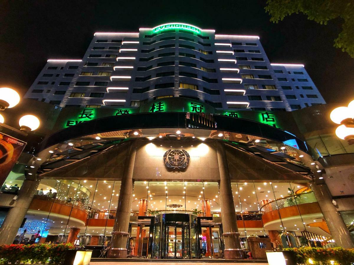 เอเวอร์กรีน เลาเรล โฮเต็ล ไทชุง Hotel ไถจง ภายนอก รูปภาพ The photo shows a modern building at night, featuring a grand entrance with illuminated signage. The structure has multiple stories with a sleek design, adorned with green lighting that highlights its architectural features. The entrance is spacious 