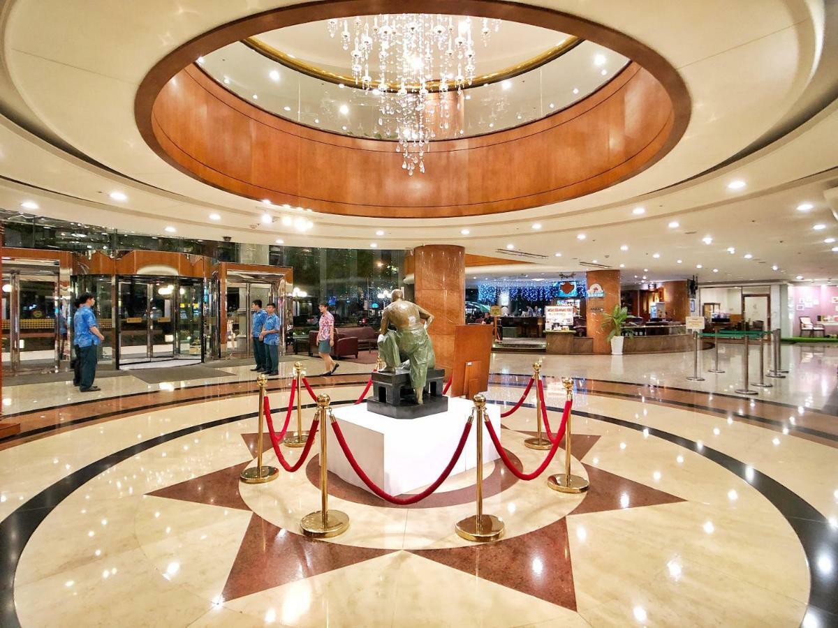 เอเวอร์กรีน เลาเรล โฮเต็ล ไทชุง Hotel ไถจง ภายนอก รูปภาพ The image shows a spacious lobby area of a building, likely a hotel or an upscale establishment. The design features a circular ceiling with a chandelier hanging from it, creating a bright and elegant ambiance. At the center, there is a statue, likel