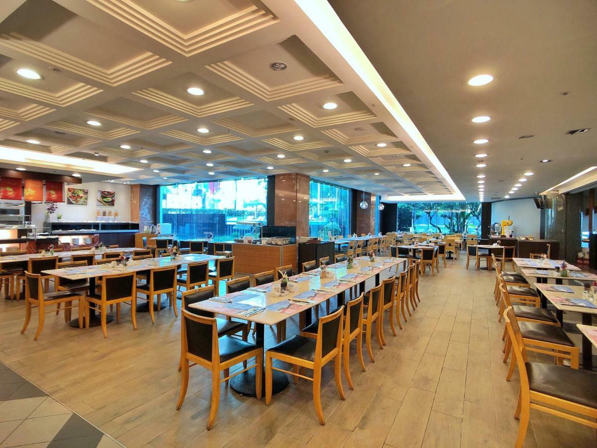 เอเวอร์กรีน เลาเรล โฮเต็ล ไทชุง Hotel ไถจง ภายนอก รูปภาพ The photo shows the interior of a restaurant. It features a spacious dining area with several wooden tables and chairs arranged in rows. The floor has a light wood finish, complementing the stylish design. The ceiling is decorated with a modern patte