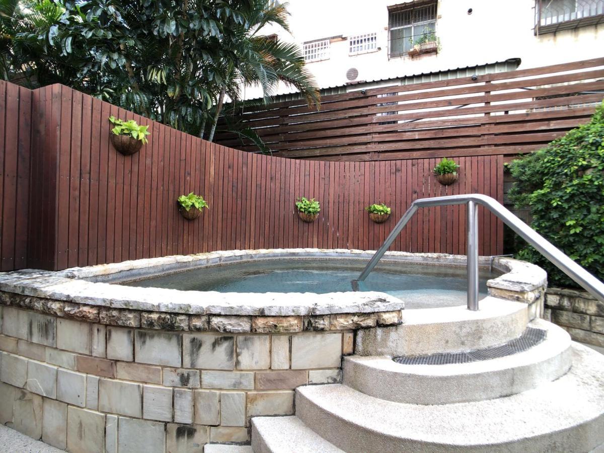 เอเวอร์กรีน เลาเรล โฮเต็ล ไทชุง Hotel ไถจง ภายนอก รูปภาพ The photo shows a small outdoor hot tub or spa area. It's surrounded by a wooden fence, with several planters containing greenery attached to the wall. The hot tub is round, with a stone border, and there are steps leading up to it with a stainless s